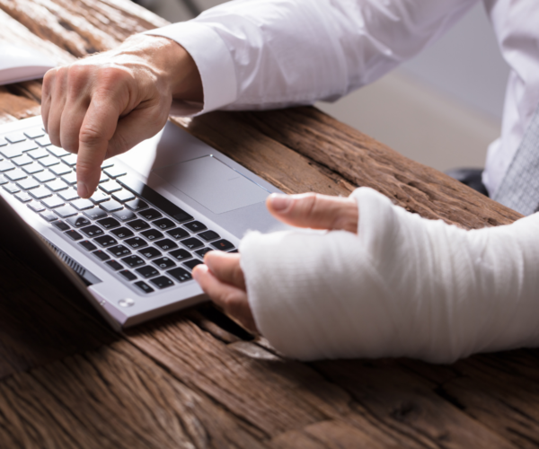 person with a cast using a laptop
